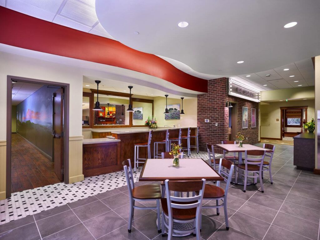 Cafe-style seating area with tables, chairs, and a bar counter.