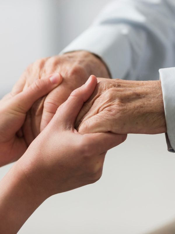 Young hands holding elderly hands in support.